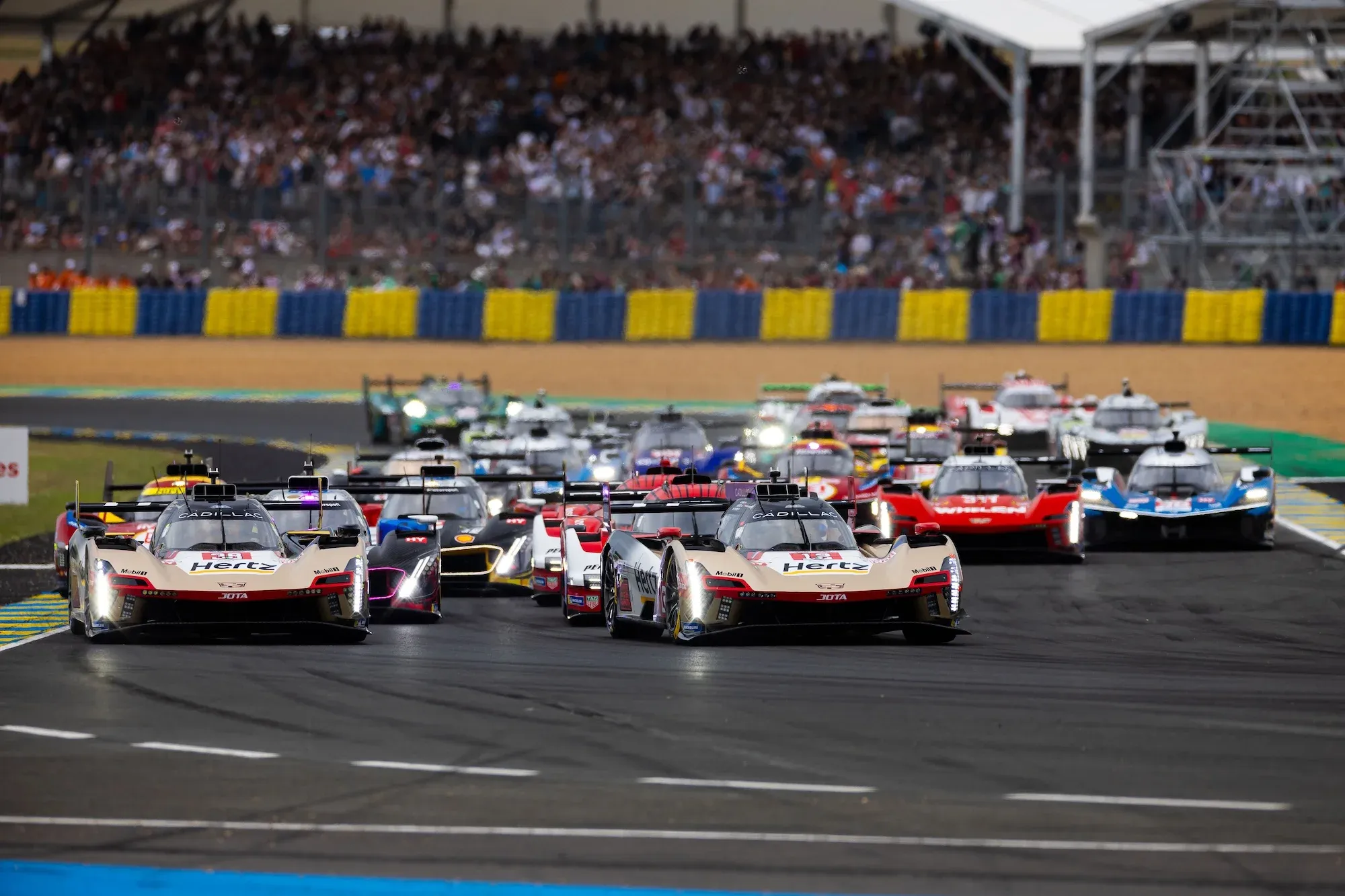 The start of the race, going into Dunlop chicane, with the two JOTA Cadillacs leading a bunched up pack