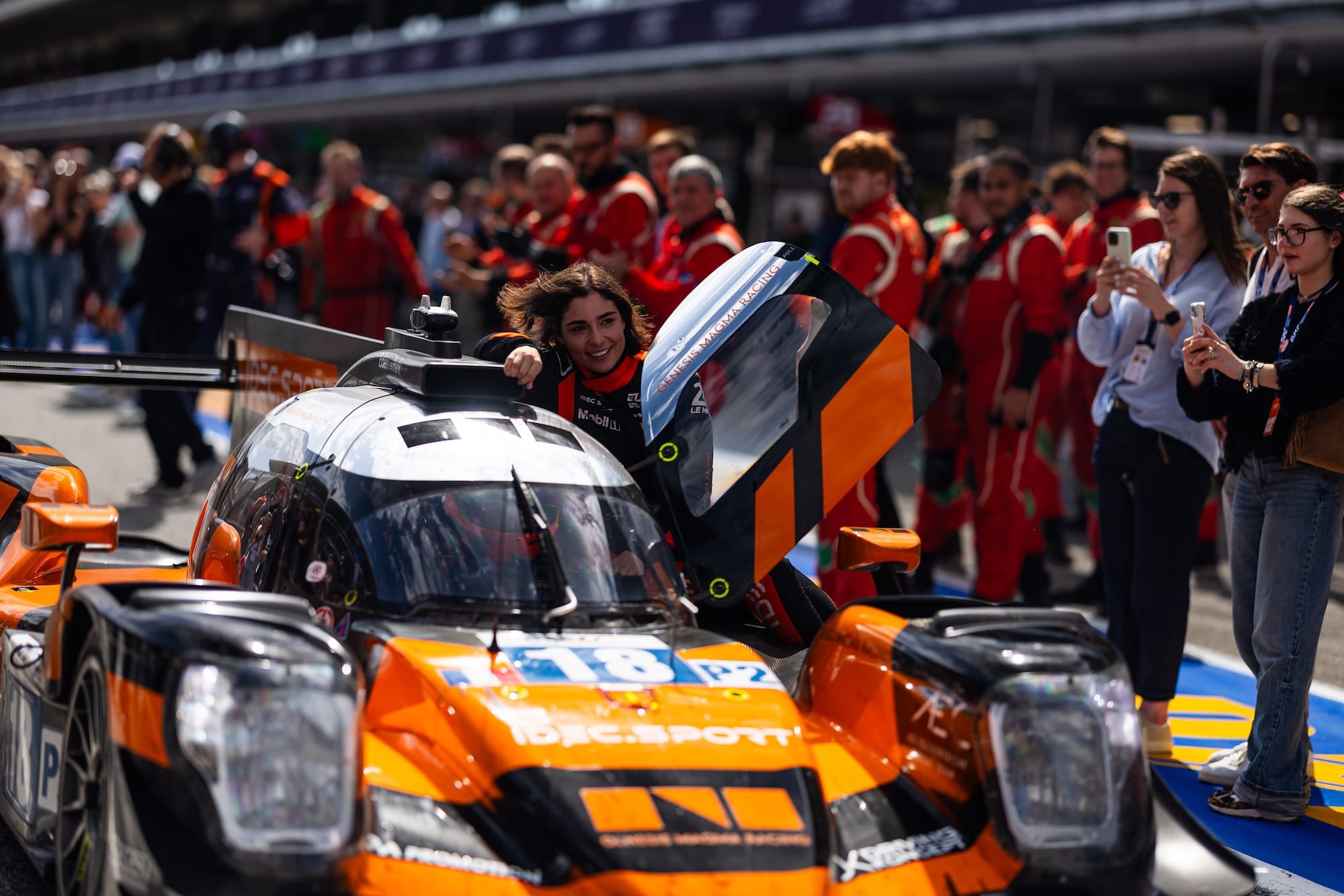 Chadwick riding on her car's sidepod with the door open as it rolls down the pitlane after winning the race, with Mathys Jaubert at the wheel.