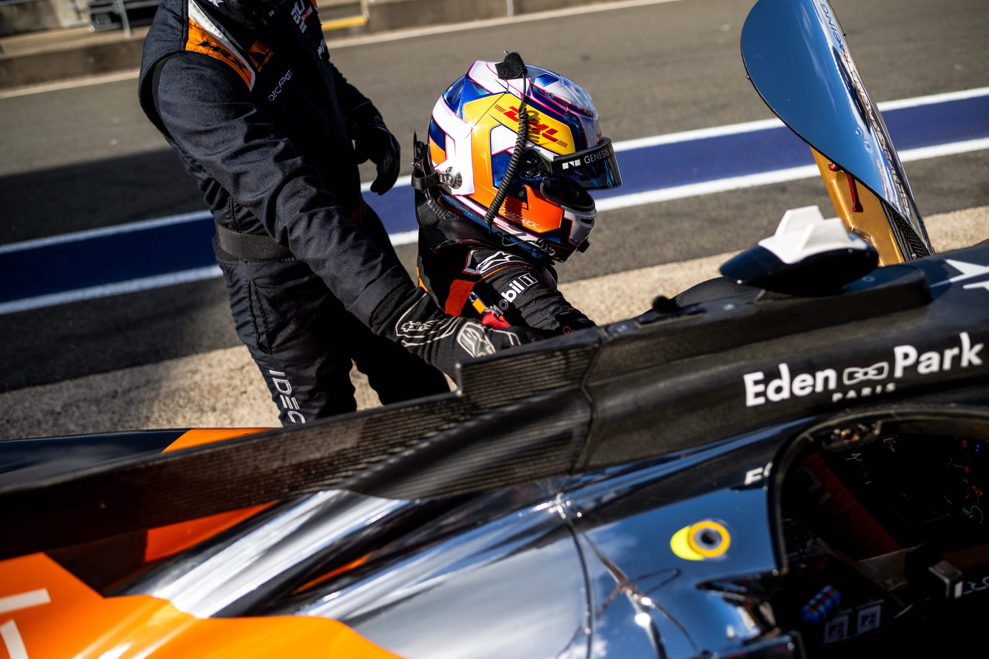 Jamie Chadwick climbing into her #18 IDEC Sport Oreca LMP2 car at Silverstone, with an engineer standing by and helping